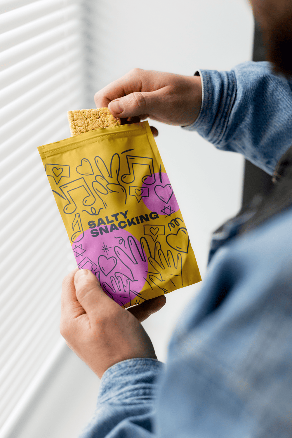 Persona sosteniendo una bolsa amarilla de 'Salty Snacking', un ejemplo de envase flexible tipo stand-up pouch para productos de gran consumo en España.
