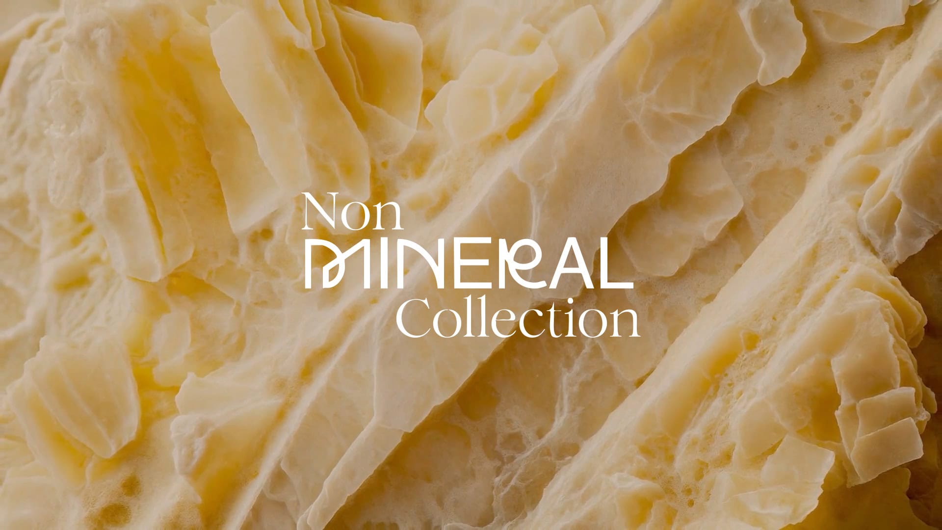 Macro shot of hard cheese texture resembling mineral crystals with the "Non Mineral Collection" logo; it’s not quartz, it’s cheese kept fresh by ReKeepEat packaging.