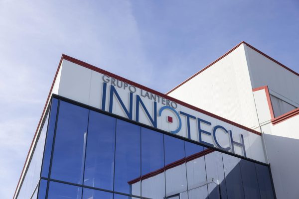 La façade moderne en verre du centre technologique Innotech du groupe Lantero sous un ciel dégagé.